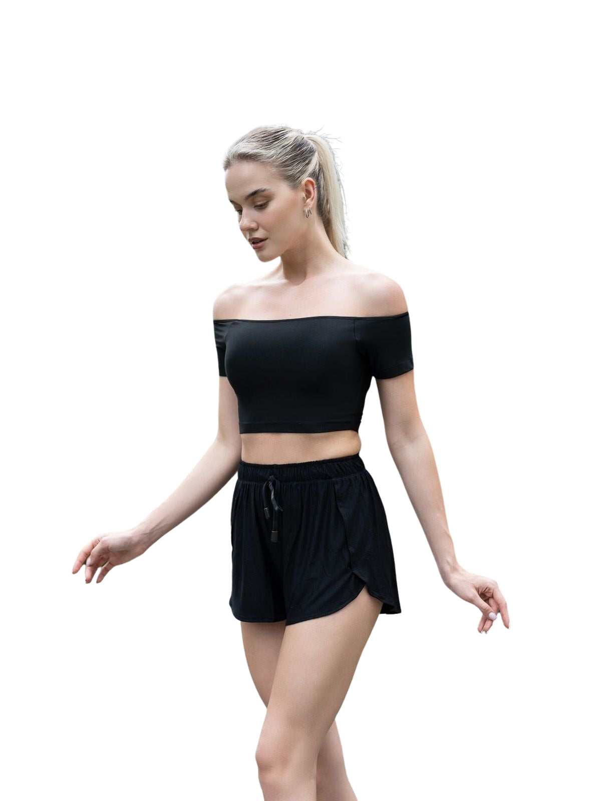 Eine Person trägt ein Comfortlux Off Shoulder T-Shirt von Lismina in Schwarz und posiert beim Tanzen vor einem weißen Hintergrund.